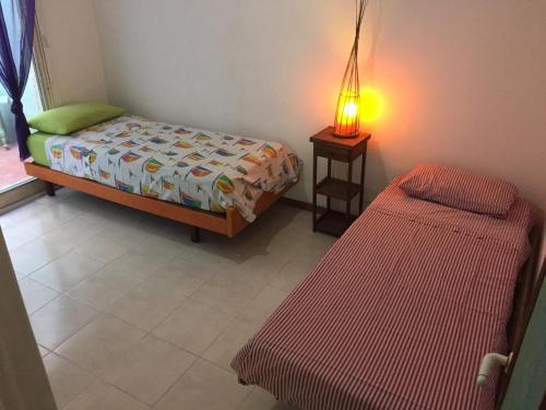 a bedroom with a bed and a table with a lamp at Hostel Casa & Campo in Buenos Aires