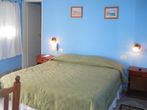 a bedroom with a bed with a blue wall at Dennisse Hotel in Victoria