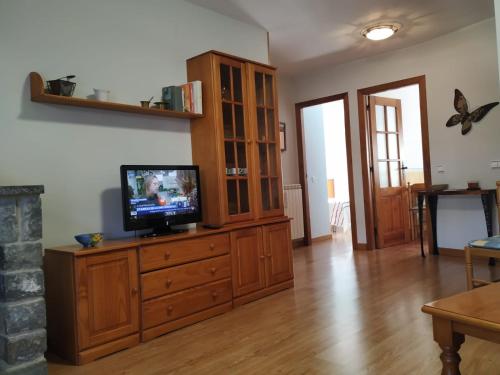 a living room with a television on a wooden cabinet at Apartamento Laera in Villanova