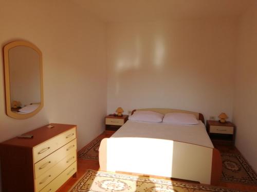 um quarto com uma cama, uma cómoda e um espelho em Apartments Ivanka em Zadar
