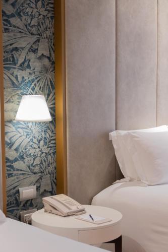 a hotel room with a bed and a table with a lamp at Manto Hotel Lima - MGallery Collection in Lima
