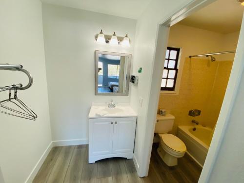 a bathroom with a sink and a toilet and a mirror at EZ 8 Motel Old Town in San Diego