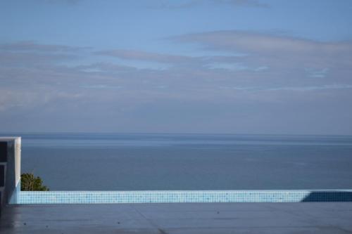 a swimming pool with the ocean in the background at Zante Fiore Suites in Xirokástellon
