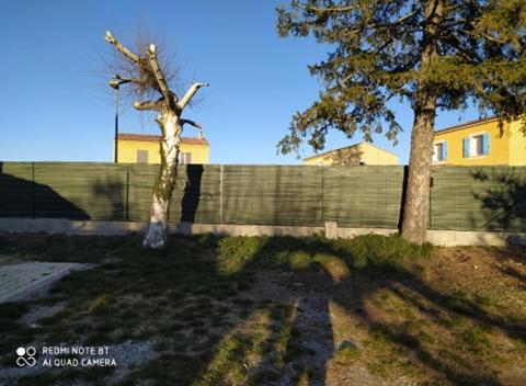 a yard with two trees and a fence at meublé 40m2 classé 2 étoiles. Lumineux les Mées 04190 in Les Mées