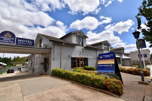 a motel sign in front of a building at Townhouse Motel Cowra in Cowra