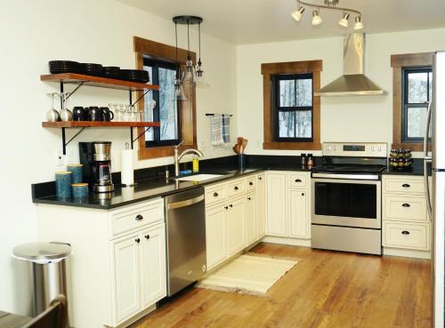 a kitchen with white cabinets and black counter tops at Silver Birch Vacation Rental in Talkeetna