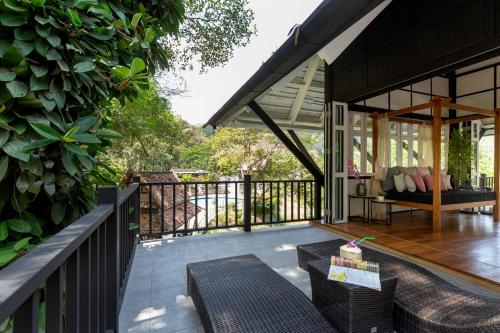 a porch of a house with a table and chairs at Patong Garden House - Luxury Villa in Patong Hills in Patong Beach