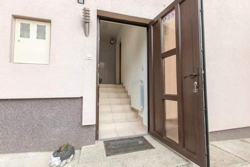 a door of a building with a cat sitting in front of it at Apartman Sunny Lika in Gospić