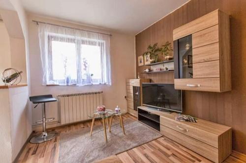 a living room with a table and a television at Apartman Sunny Lika in Gospić