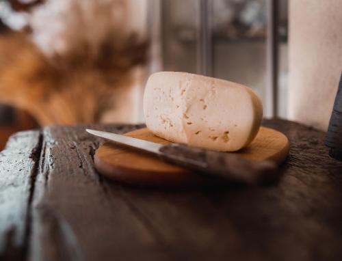 a piece of cheese on a cutting board with a knife at Agriturismo La Torretta in Siena