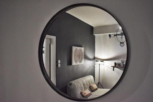 a mirror in a room with a chair and a lamp at Suite Tic by Be My Guest in Athens