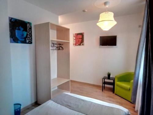 a bedroom with a bed and a green chair at Central Guesthouse in Bucharest