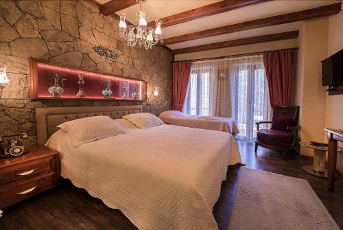 a bedroom with a large bed and a stone wall at Kazdaglari Karye Müze Hotel in Kucukkuyu