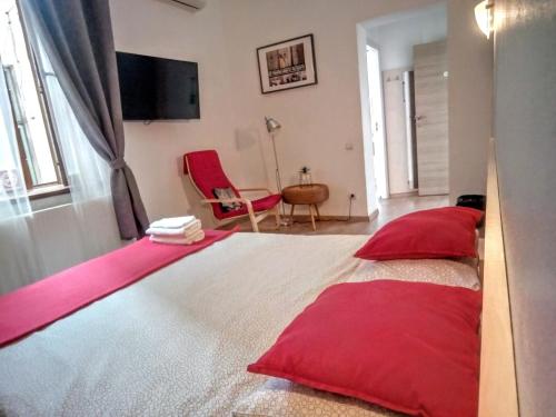 a bedroom with a large bed with red pillows at Central Guesthouse in Bucharest