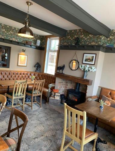 a living room with a fireplace and a table and chairs at The Griffin Inn in Saint Helens
