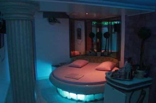 a bedroom with a round bed with a mirror at Motel Le Plaisir in Salvador