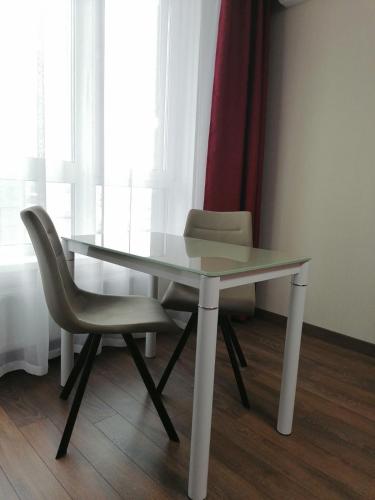a glass table and two chairs in a room at Solo Apartment Kamenskaya in Kyiv