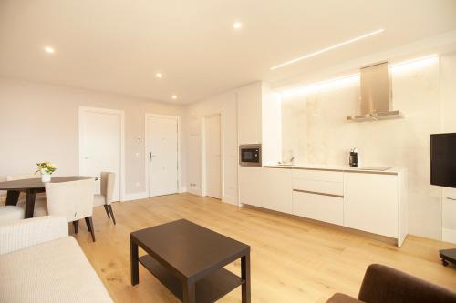 a living room with a kitchen and a table at Apartamentos Reina Victoria in Santander
