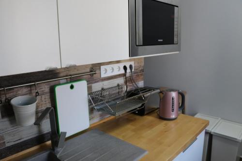 uma cozinha com um balcão com um micro-ondas e uma mesa em Petofi Apartman em Szeged