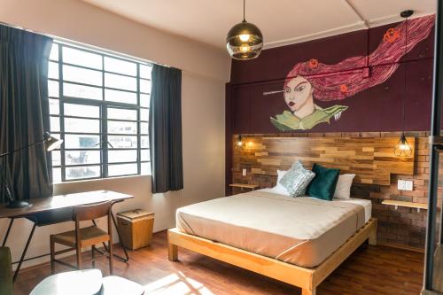 een slaapkamer met een bed en een schilderij aan de muur bij Selina Mexico City Downtown in Mexico-Stad