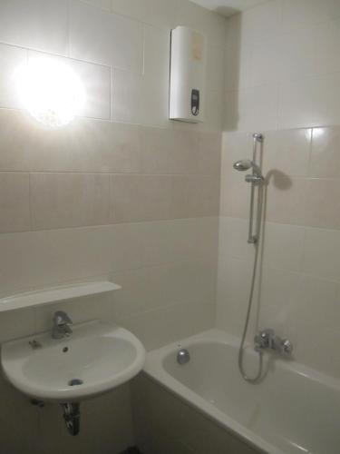 a white bathroom with a sink and a bath tub at Berggasthof Bayernturm in Zimmerau