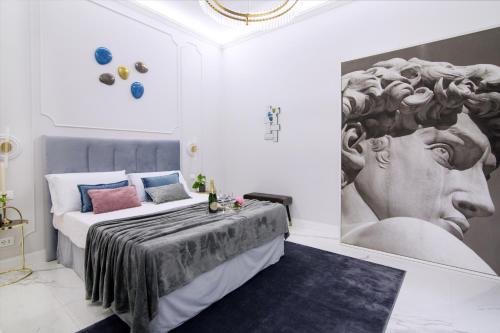 sypialnia z łóżkiem z obrazem na ścianie w obiekcie Roma Deluxe Apartments w Rzymie