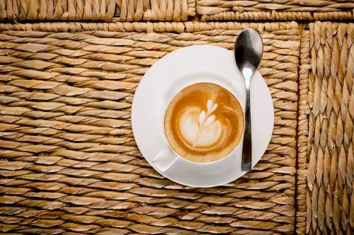 a cup of coffee and a spoon on a table at Hotel Parque México Boutique in Mexico City