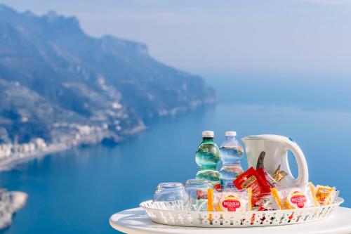 a basket of drinks and bottles on a table with a view at Casa Dolce Casa Ravello in Ravello