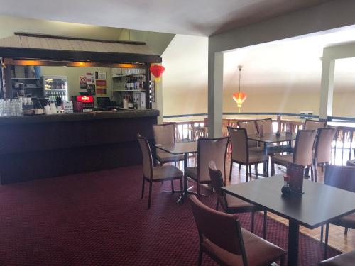 a dining room with tables and chairs and a bar at Lucy Lodge in Charlotte Pass