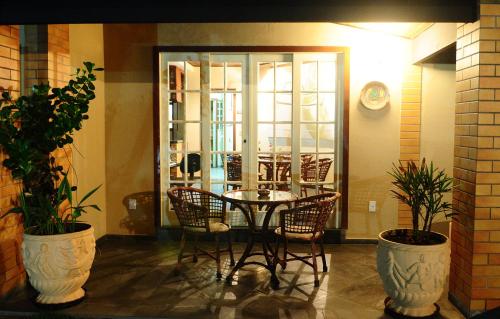 a table and chairs in a room with plants at Pousada Genesis in Arraial do Cabo
