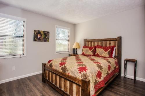 1 dormitorio con cama de madera y almohadas rojas en Fox's Den, Hot Tub, FREE Attraction tickets for each paid day, Arcade Game, WIFI!!!, en Pigeon Forge