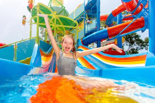 a young girl playing on a water slide in a water park at BIG4 Gold Coast Holiday Park in Gold Coast