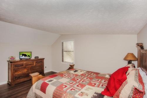 a bedroom with a bed and a dresser at Fox's Den, Hot Tub, FREE Attraction tickets for each paid day, Arcade Game, WIFI!!! in Pigeon Forge