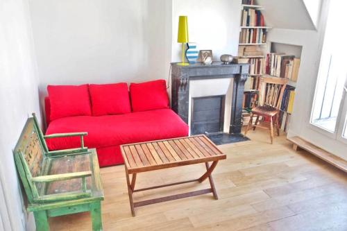 a living room with a red couch and a fireplace at Very Nice Apartment Between Pigalle And Montmartre in Paris