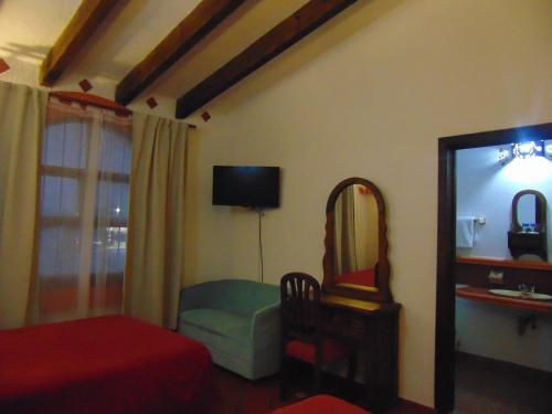 a living room with a mirror and a chair and a mirror at La casa de la abuela in San Cristóbal de Las Casas