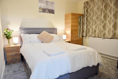 a bedroom with a large white bed and a window at 3 Bedroom London Home in London