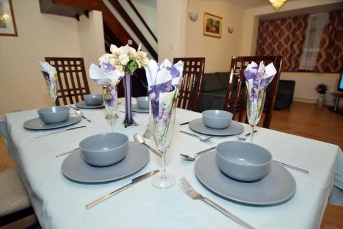 a table with plates and bowls and vases on it at 3 Bedroom London Home in London