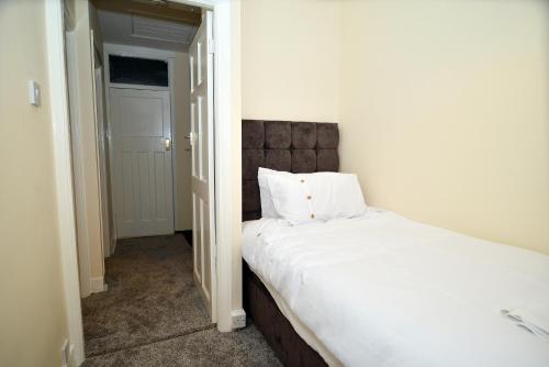 a bedroom with two beds and a door to a room at 3 Bedroom London Home in London