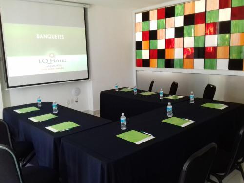 two tables in a room with a screen with a presentation at La Quinta by Wyndham Puebla Palmas Angelopolis in Puebla