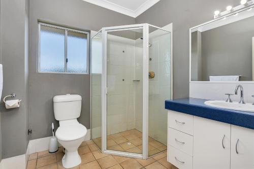 a bathroom with a shower, toilet and sink at Cairns Reef Apartments & Motel in Cairns