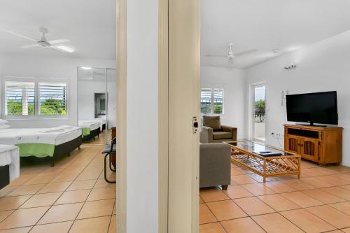 a living room filled with furniture and a tv at Cairns Reef Apartments & Motel in Cairns
