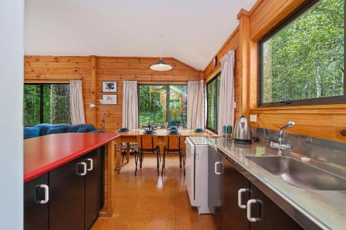una cucina e una sala da pranzo con tavolo e sedie di Puka Lodge Rear dwelling - Pukawa Bay Home a Kuratau