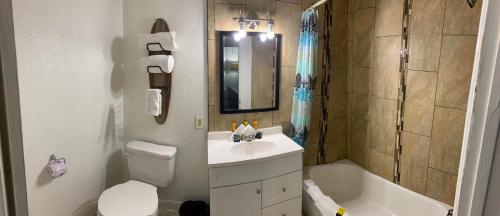 a bathroom with a sink and a toilet and a tub at Desert Hills Motel in Las Vegas