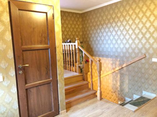 a hallway with a wooden door and a staircase at Giorgi's Guest House in Stepantsminda