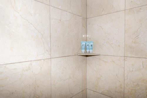 un bagno con pareti in marmo bianco e una mensola con due servizi igienici di Ocean Beach Hotel a Miami Beach
