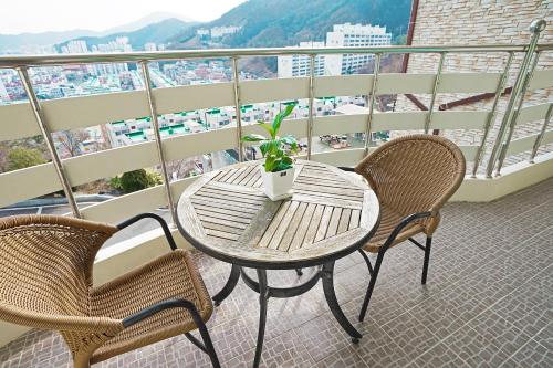 a table and two chairs on a balcony at Home Fourest Resort Geoje in Geoje 