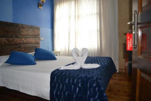 a bedroom with a bed with a white bow on it at Posada la Leyenda in Santillana del Mar