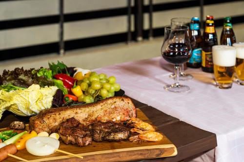 a table with a plate of food and a glass of wine at Home Fourest Resort Geoje in Geoje 