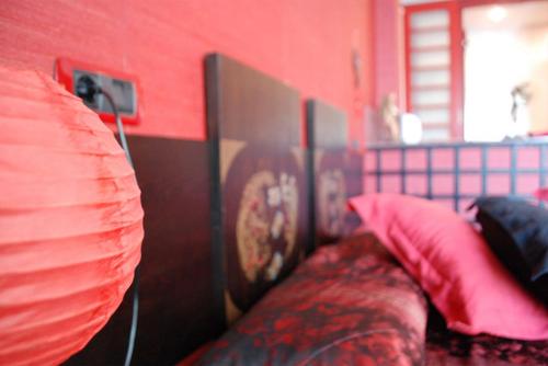 a red room with a bed with red pillows at Posada la Leyenda in Santillana del Mar