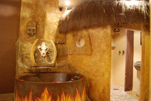 a bathroom with aburning tub with a statue of a cow at Posada la Leyenda in Santillana del Mar
